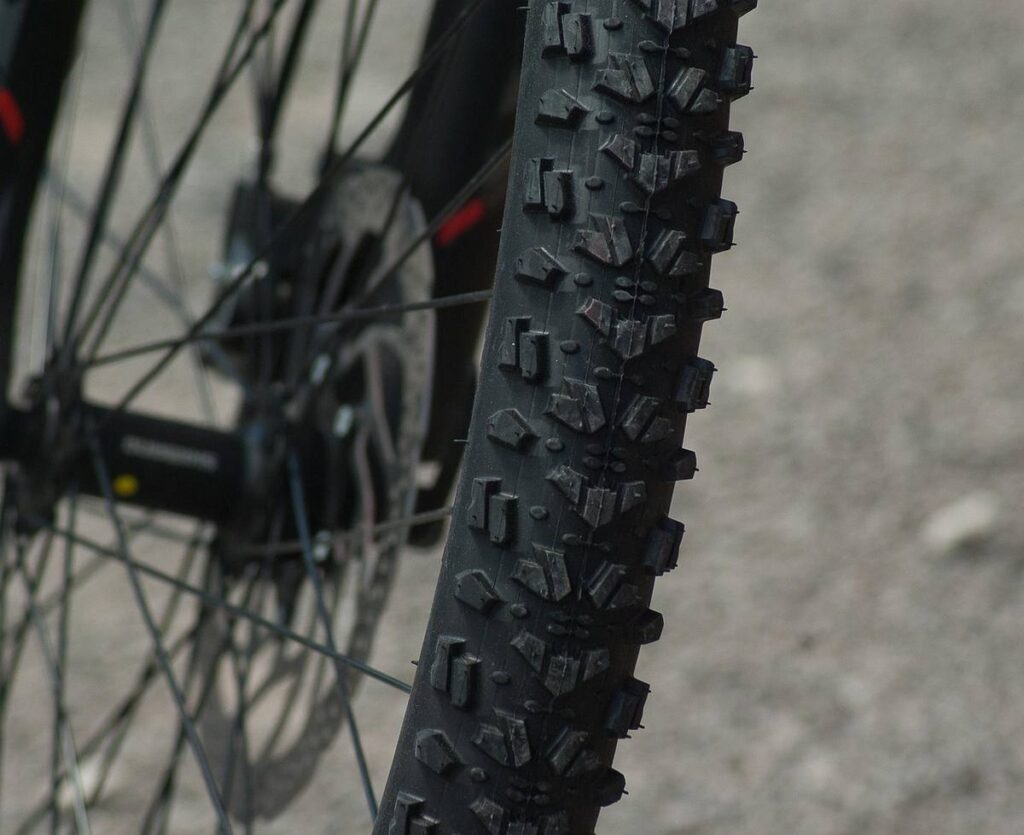 Gros plan du pneu crantele d'un vélo de montagne, prise de côté en extérieur