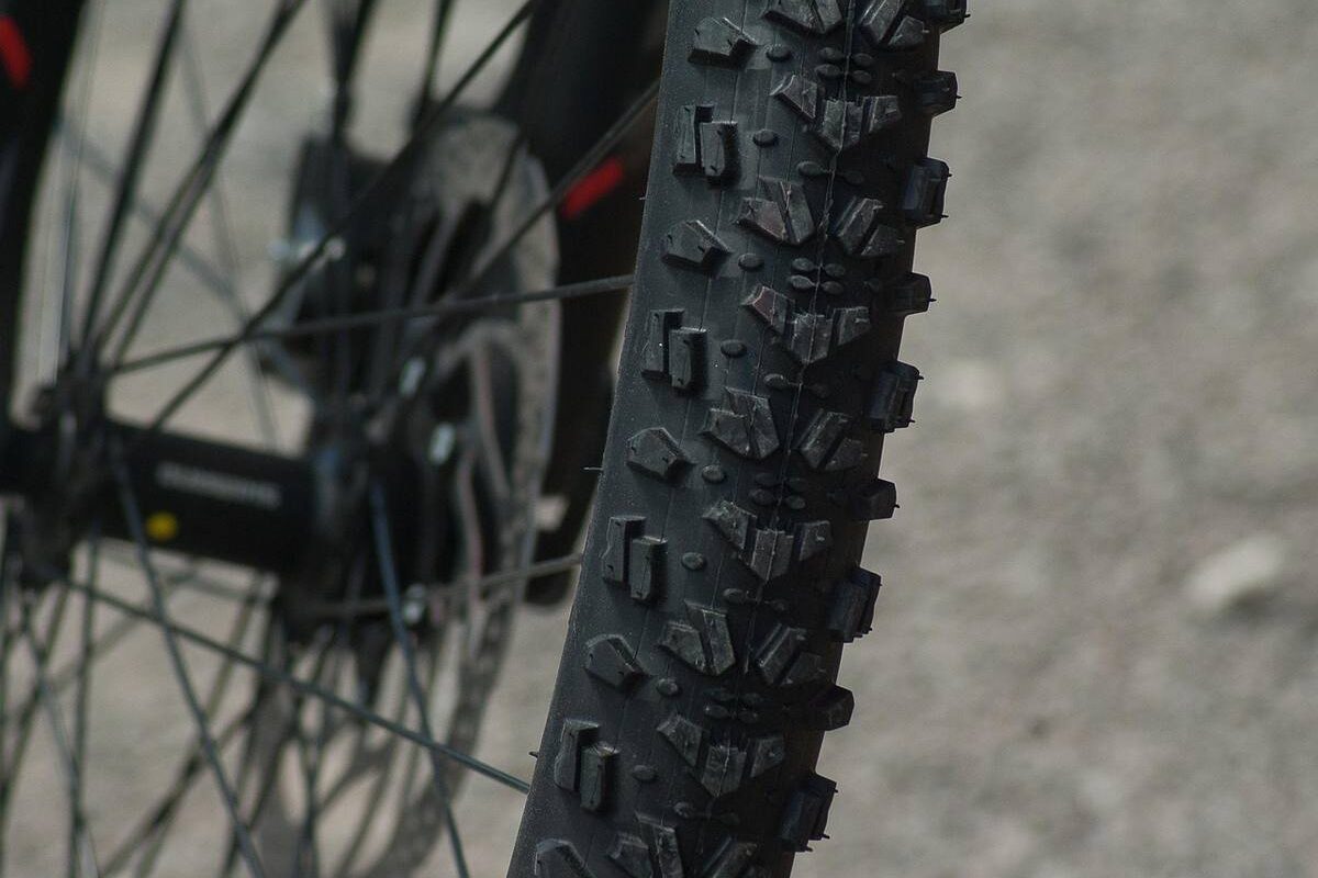 Gros plan du pneu crantele d'un vélo de montagne, prise de côté en extérieur